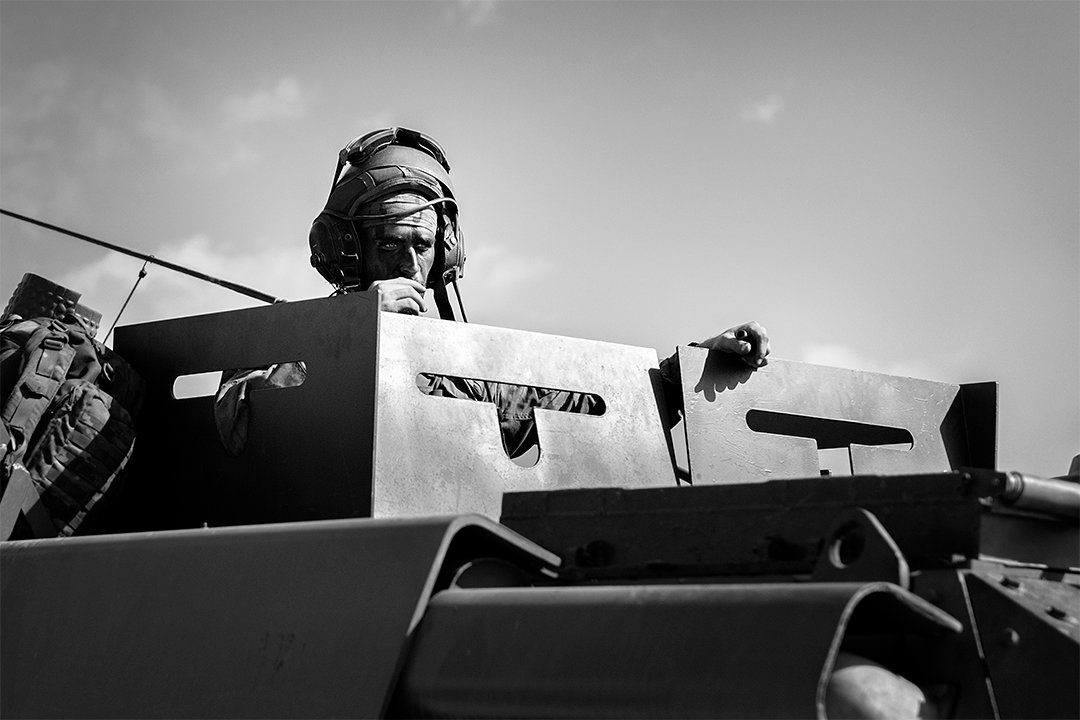 A service member on an armoured vehicle.
